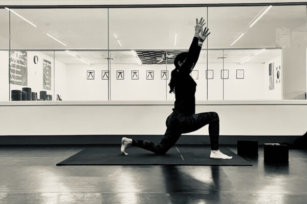 Black and white photo of a person doing yoga in a studio.