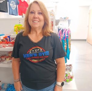 Ada in the Pro Shop wearing a Ken's Gym shirt.